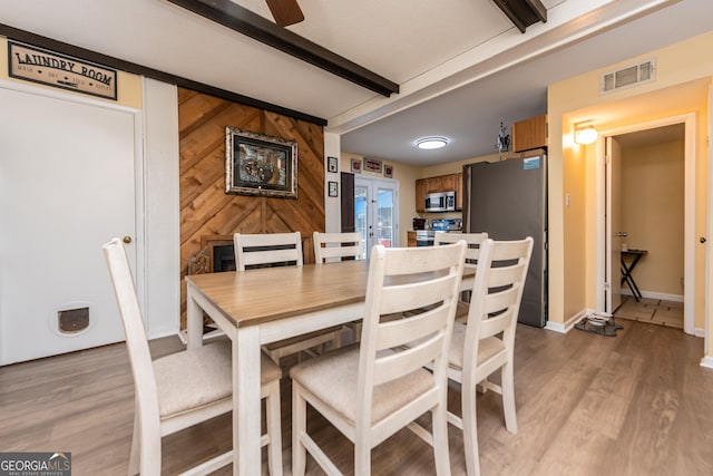 141 Stoneridge Dr, Warner Robins, GA 31088 - dining room with beam ceiling, light wood-style flooring, baseboards, wooden walls, and ceiling fan