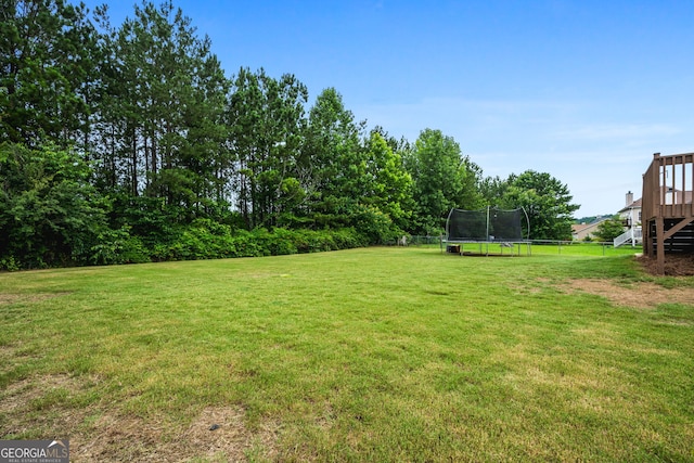 167 Maggies Pt, Dallas, GA 30132 - view of green lawn with a trampoline, a deck, and stairway