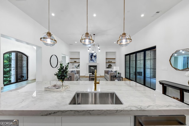 4235 Drew Campground Rd, Alpharetta, GA 30004 - kitchen with open floor plan, a center island with sink, light stone counters, built in shelves, and recessed lighting