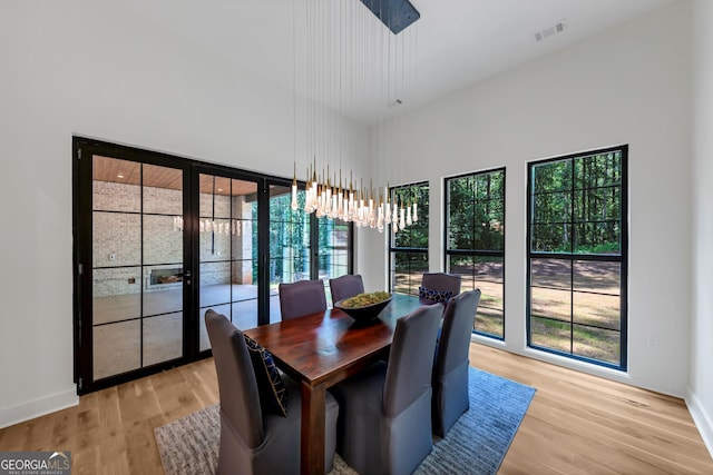 4235 Drew Campground Rd, Alpharetta, GA 30004 - dining space with a high ceiling, light wood finished floors, and a chandelier