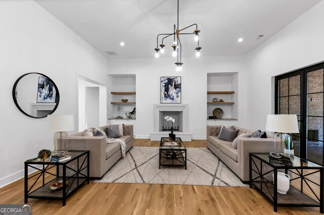 4235 Drew Campground Rd, Alpharetta, GA 30004 - living room featuring built in features, wood finished floors, recessed lighting, and a fireplace with raised hearth
