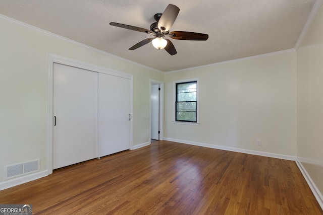 256 4th Ave, Winder, GA 30680 - unfurnished bedroom featuring wood finished floors, crown molding, a closet, and a ceiling fan