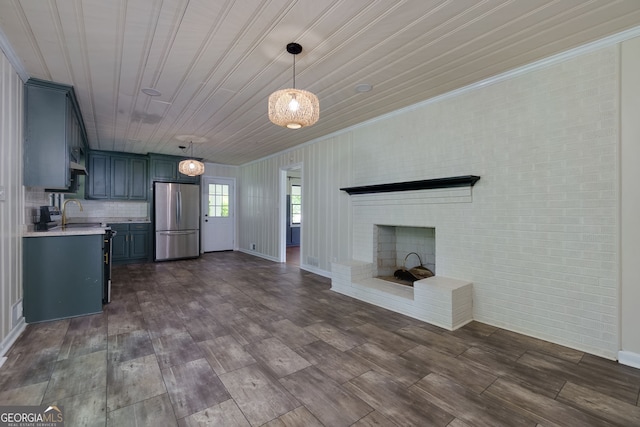 256 4th Ave, Winder, GA 30680 - kitchen featuring freestanding refrigerator, light countertops, blue cabinets, open floor plan, and a fireplace
