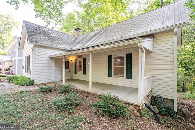 546 Pulaski St, Athens, GA 30601 - view of front of house with metal roof, covered porch, and a chimney