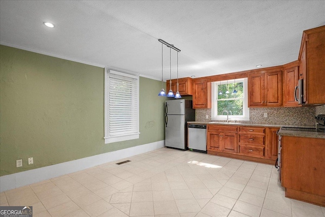 546 Pulaski St, Athens, GA 30601 - kitchen featuring appliances with stainless steel finishes, a sink, tasteful backsplash, brown cabinets, and a textured ceiling