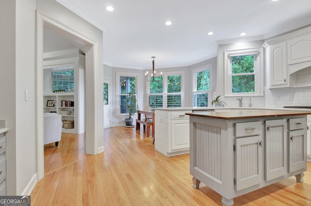 505 Lighthouse Ln, Peachtree City, GA 30269 - kitchen with ornamental molding, a chandelier, white cabinets, wood counters, and light wood-style floors