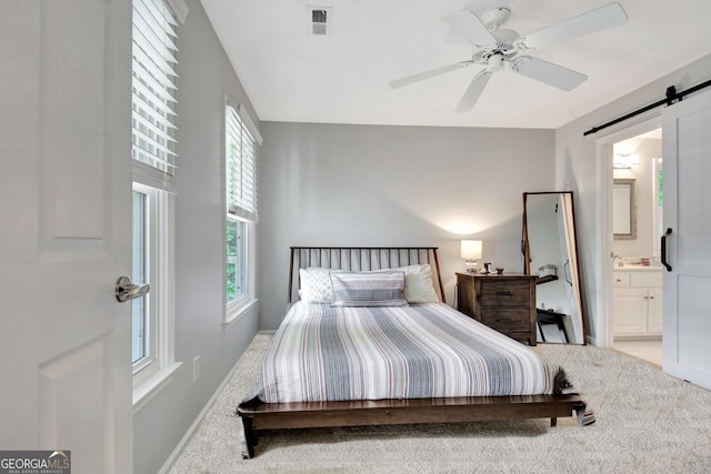 505 Lighthouse Ln, Peachtree City, GA 30269 - bedroom with light carpet, a barn door, baseboards, and ensuite bathroom