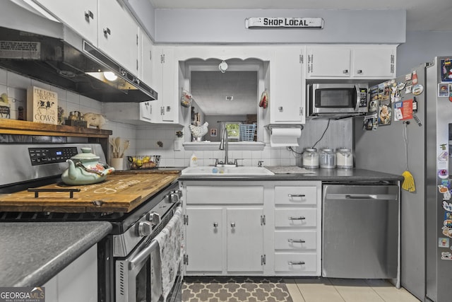 314 Clifton Dr, Port Wentworth, GA 31407 - kitchen with appliances with stainless steel finishes, under cabinet range hood, dark countertops, and tasteful backsplash