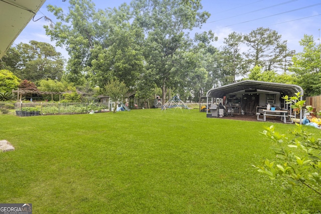 314 Clifton Dr, Port Wentworth, GA 31407 - view of yard with a detached carport, a playground, and view of wooded area