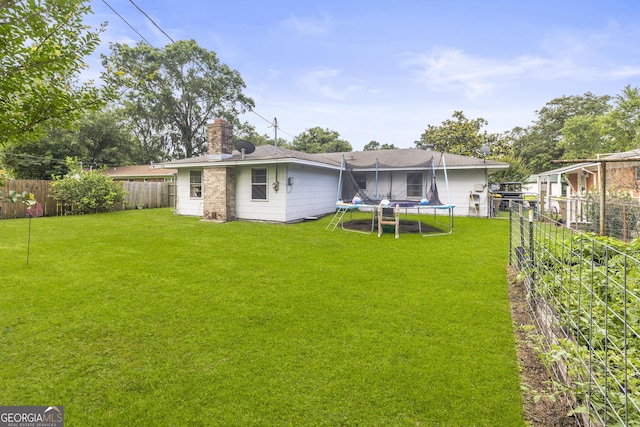 314 Clifton Dr, Port Wentworth, GA 31407 - back of property featuring a trampoline, a chimney, and a fenced backyard