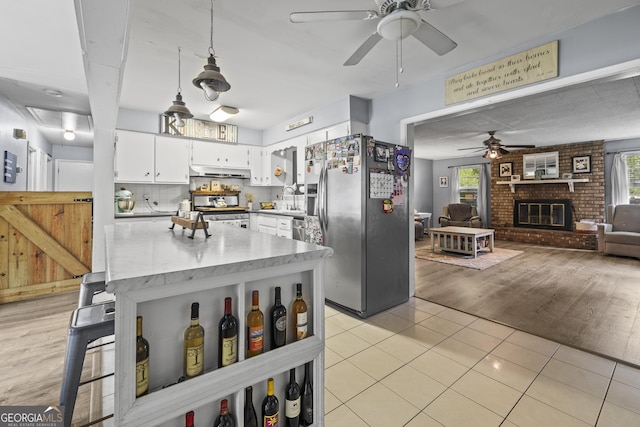 314 Clifton Dr, Port Wentworth, GA 31407 - kitchen featuring appliances with stainless steel finishes, ceiling fan, under cabinet range hood, white cabinets, and light countertops