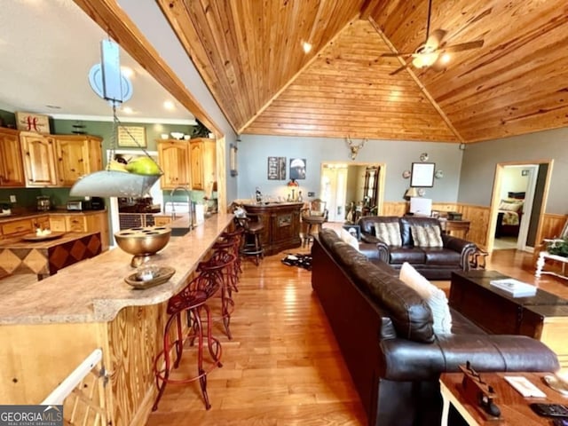 657 Halls Bridge Rd, Swainsboro, GA 30401 - living room with light wood finished floors, wooden ceiling, wainscoting, a ceiling fan, and vaulted ceiling