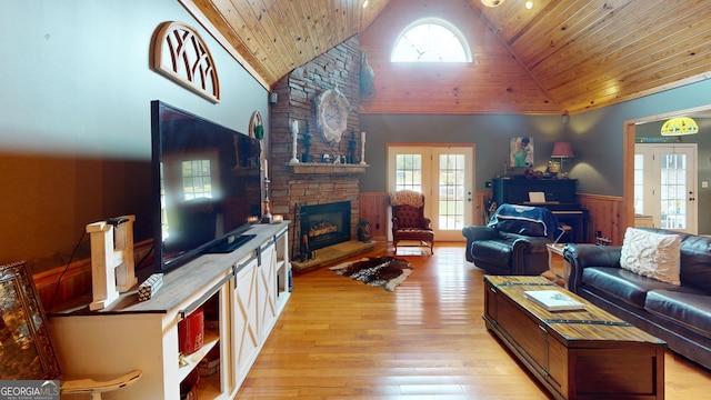 657 Halls Bridge Rd, Swainsboro, GA 30401 - living room featuring a wainscoted wall, wood ceiling, a stone fireplace, light wood finished floors, and healthy amount of natural light