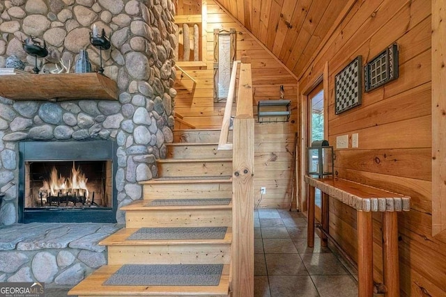 9 Dean Ct, Blue Ridge, GA 30513 - staircase featuring lofted ceiling, wooden ceiling, a stone fireplace, tile patterned floors, and wooden walls