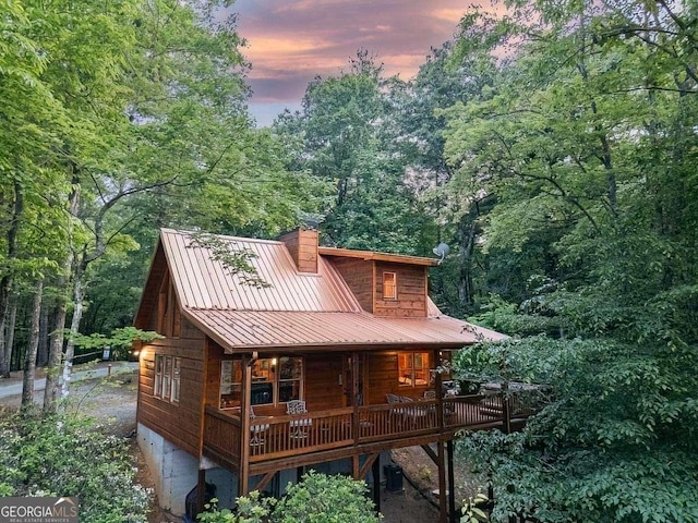 9 Dean Ct, Blue Ridge, GA 30513 - back of house at dusk with a chimney, a metal roof, covered porch, and a forest view