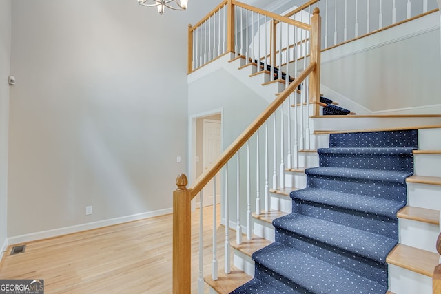 2230 Huntingdon Ct, Gainesville, GA 30506 - staircase with wood finished floors, a chandelier, and a towering ceiling