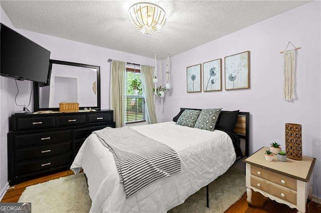 69 Due W Pass, Dallas, GA 30157 - bedroom with wood finished floors, a textured ceiling, and a chandelier