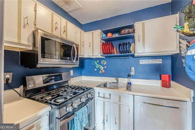 1705 Monroe Dr NE Unit D05, Atlanta, GA 30324 - kitchen featuring appliances with stainless steel finishes, light countertops, open shelves, and white cabinetry
