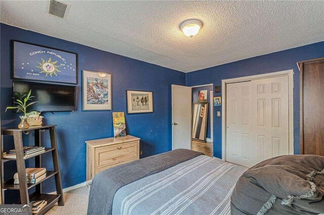 1705 Monroe Dr NE Unit D05, Atlanta, GA 30324 - bedroom featuring a textured ceiling and carpet floors