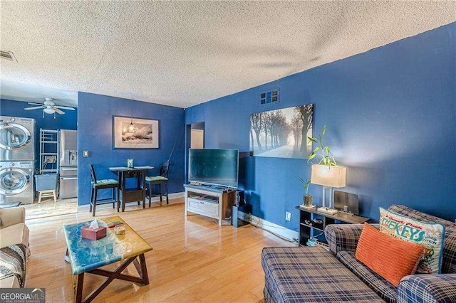 1705 Monroe Dr NE Unit D05, Atlanta, GA 30324 - living area with stacked washer and clothes dryer, a textured ceiling, wood finished floors, and a ceiling fan