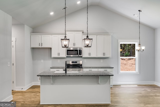 TRACT3 Georgia Highway 100, Buchanan, GA 30113 - kitchen featuring stainless steel appliances, white cabinets, a center island with sink, dark stone counters, and light wood-style floors