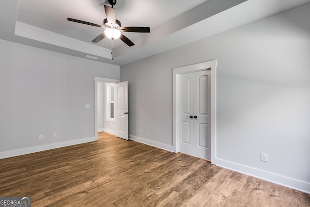 TRACT3 Georgia Highway 100, Buchanan, GA 30113 - unfurnished bedroom featuring wood finished floors, a raised ceiling, a closet, and a ceiling fan