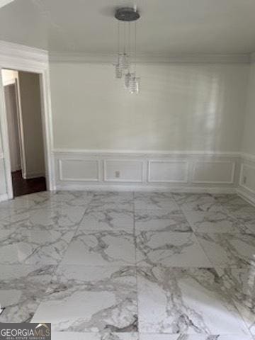 121 Fountain Oak, Villa Rica, GA 30180 - unfurnished dining area featuring a decorative wall, a wainscoted wall, ornamental molding, and marble finish floors