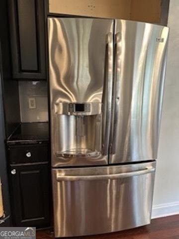 121 Fountain Oak, Villa Rica, GA 30180 - detailed view of stainless steel fridge with ice dispenser, dark countertops, dark wood-style flooring, and dark cabinets