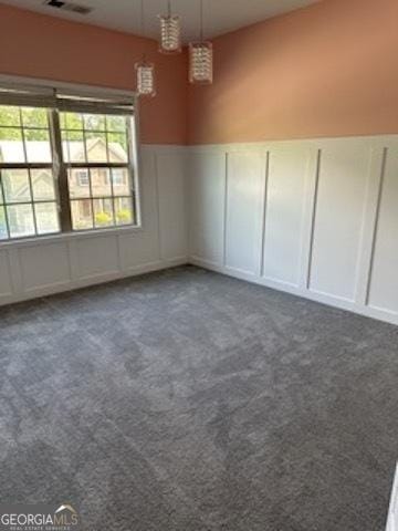 121 Fountain Oak, Villa Rica, GA 30180 - empty room featuring a decorative wall, dark colored carpet, a wainscoted wall, and a chandelier