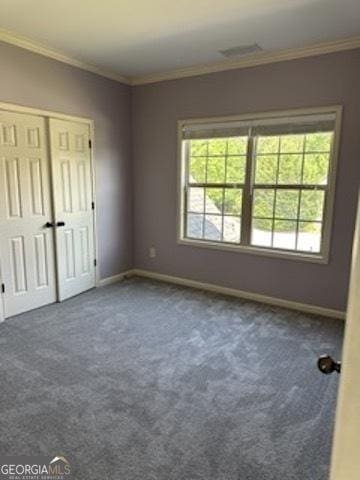 121 Fountain Oak, Villa Rica, GA 30180 - unfurnished bedroom with multiple windows, ornamental molding, dark colored carpet, and a closet
