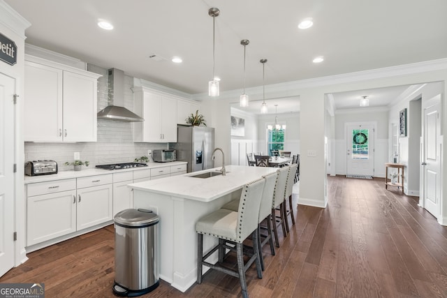 2884 Porches Ln, Dacula, GA 30019 - kitchen with wall chimney range hood, a sink, stainless steel appliances, a kitchen island with sink, and white cabinetry