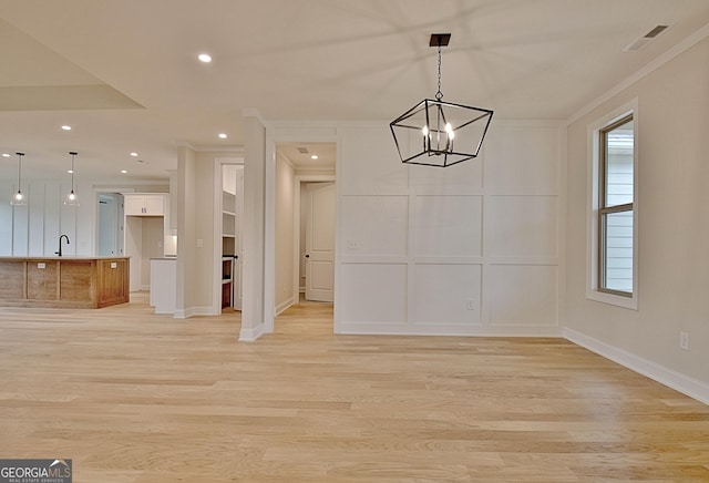 375 Werner Way, Senoia, GA 30276 - unfurnished dining area with crown molding, light wood finished floors, a chandelier, recessed lighting, and a decorative wall