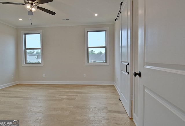 375 Werner Way, Senoia, GA 30276 - empty room featuring healthy amount of natural light, ornamental molding, ceiling fan, a barn door, and light wood-style floors