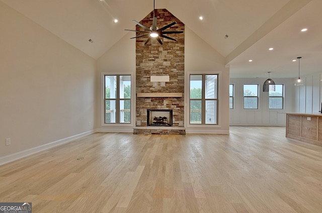 375 Werner Way, Senoia, GA 30276 - unfurnished living room featuring light wood-type flooring, high vaulted ceiling, a stone fireplace, a ceiling fan, and recessed lighting