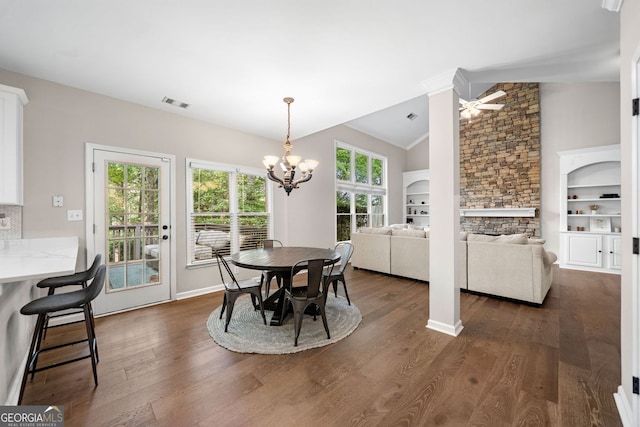 1205 Compass Pointe Xing, Alpharetta, GA 30005 - dining room with a chandelier, vaulted ceiling, dark wood-style flooring, a stone fireplace, and a ceiling fan