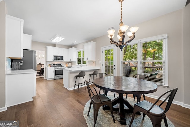 1205 Compass Pointe Xing, Alpharetta, GA 30005 - dining room featuring a chandelier, dark wood-type flooring, healthy amount of natural light, and baseboards