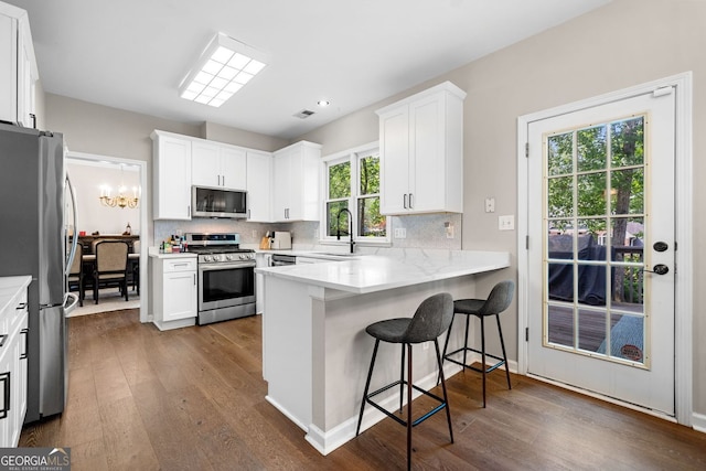 1205 Compass Pointe Xing, Alpharetta, GA 30005 - kitchen with appliances with stainless steel finishes, a peninsula, dark wood-style floors, backsplash, and recessed lighting
