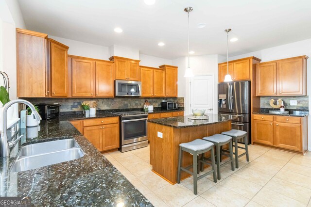 441 Spring View Dr, Woodstock, GA 30188 - kitchen featuring appliances with stainless steel finishes, a sink, a center island, decorative backsplash, and brown cabinetry