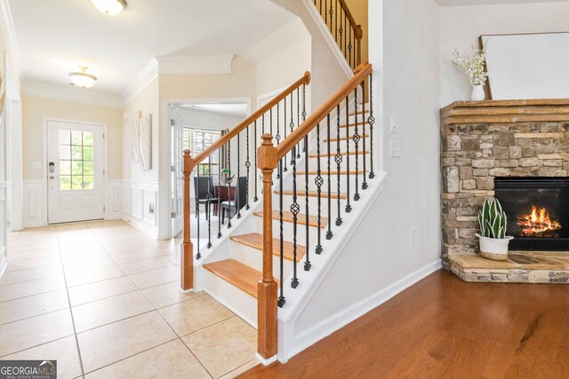 441 Spring View Dr, Woodstock, GA 30188 - foyer with stairs, a fireplace, crown molding, a wainscoted wall, and a decorative wall