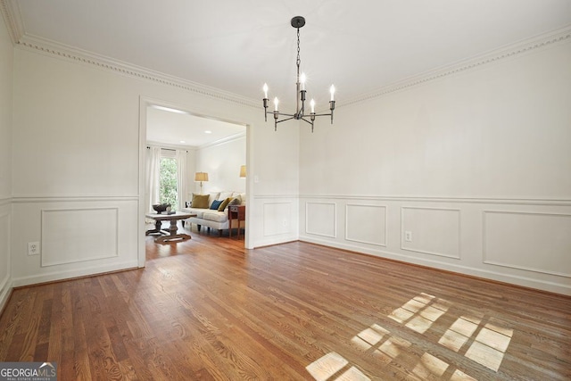 11940 Mountain Laurel Dr, Roswell, GA 30075 - dining area featuring a decorative wall, a chandelier, crown molding, wood finished floors, and a wainscoted wall