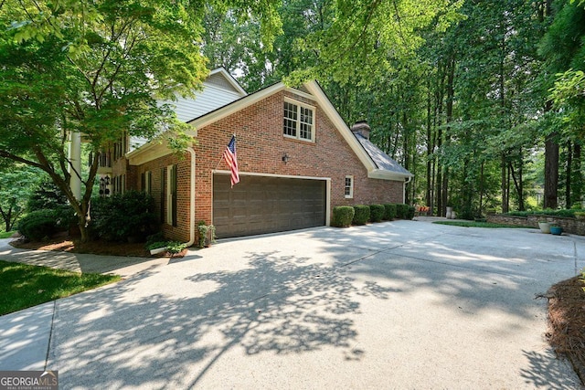 11940 Mountain Laurel Dr, Roswell, GA 30075 - view of side of property featuring concrete driveway, brick siding, a chimney, and a garage