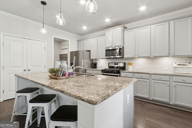 836 Hawkins Creek Dr, Jefferson, GA 30549 - kitchen with appliances with stainless steel finishes, ornamental molding, backsplash, a kitchen island with sink, and dark wood-type flooring
