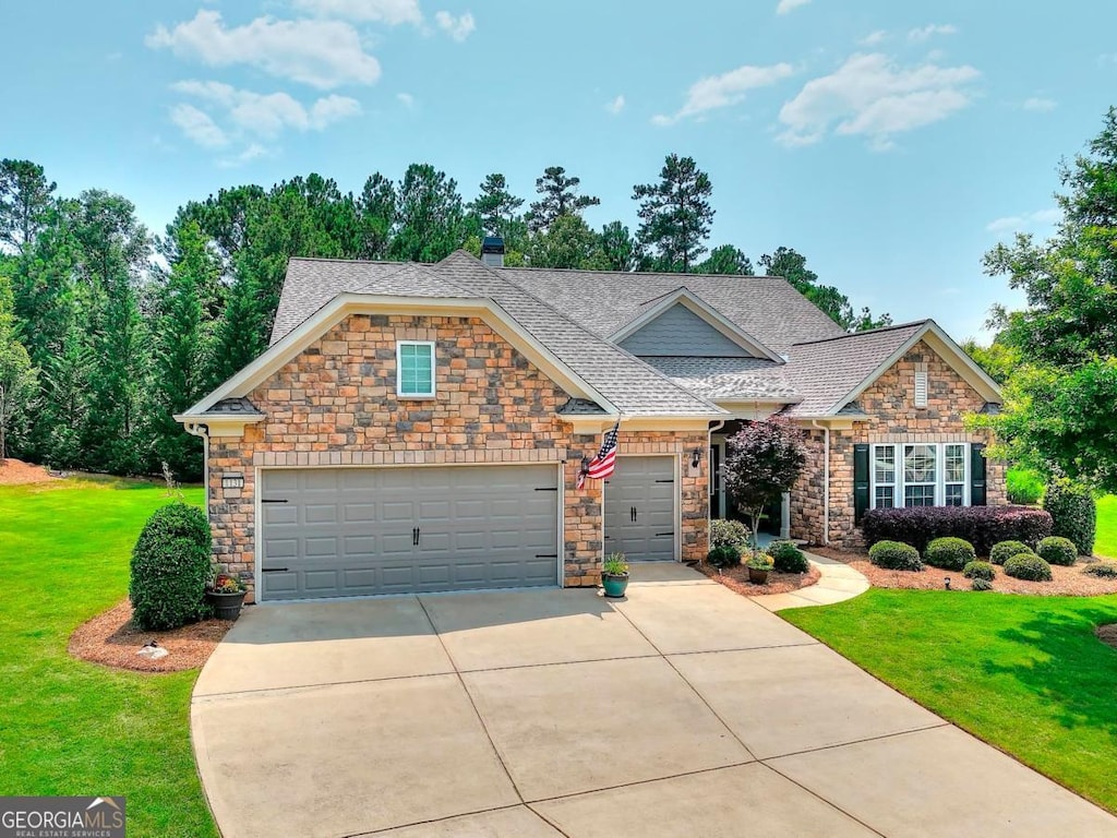 1131 Lake Front Ct, Greensboro, GA 30642 - craftsman-style home featuring stone siding, a front lawn, driveway, and a garage