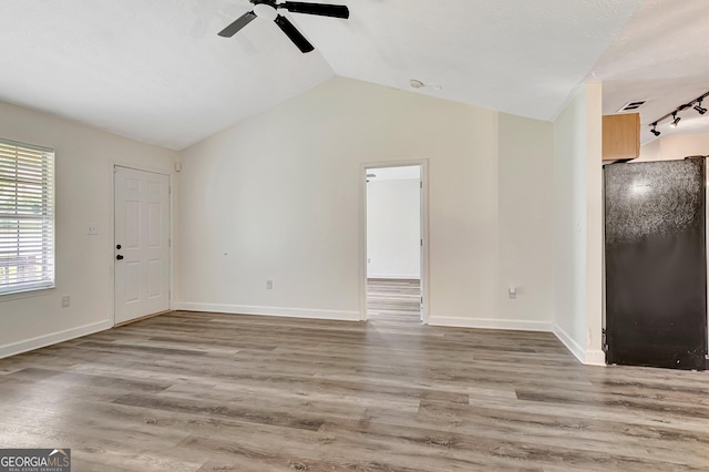 85 Prestigious Pl, Senoia, GA 30276 - unfurnished living room featuring a ceiling fan, vaulted ceiling, wood finished floors, and baseboards