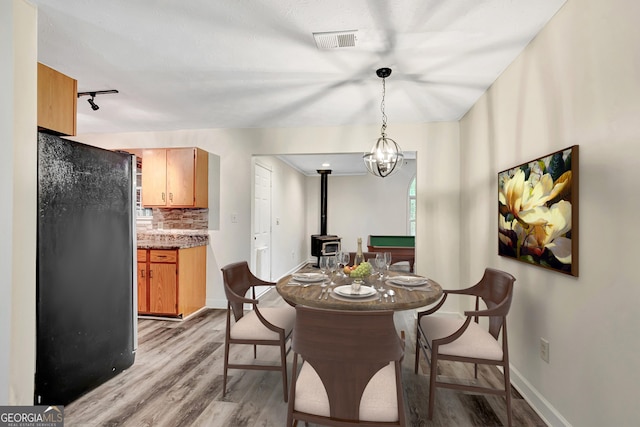 85 Prestigious Pl, Senoia, GA 30276 - dining area with a wood stove, light wood-style flooring, baseboards, and rail lighting