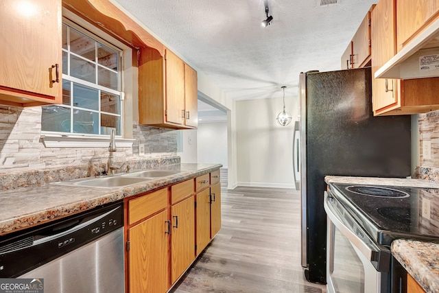 85 Prestigious Pl, Senoia, GA 30276 - kitchen featuring appliances with stainless steel finishes, under cabinet range hood, a sink, backsplash, and baseboards