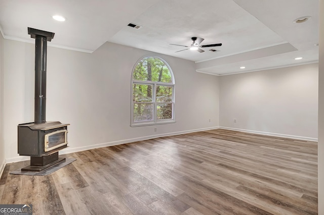 85 Prestigious Pl, Senoia, GA 30276 - unfurnished living room featuring crown molding, ceiling fan, wood finished floors, baseboards, and a wood stove