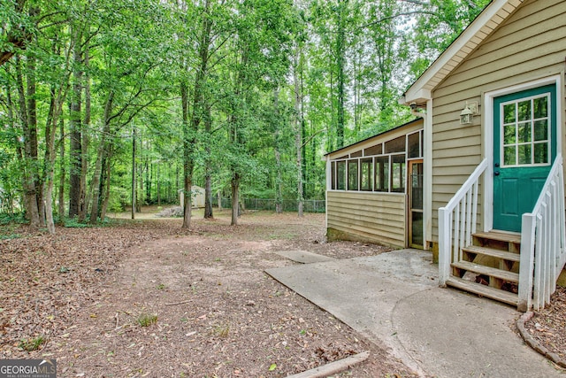 85 Prestigious Pl, Senoia, GA 30276 - view of yard featuring a sunroom, entry steps, and a view of trees