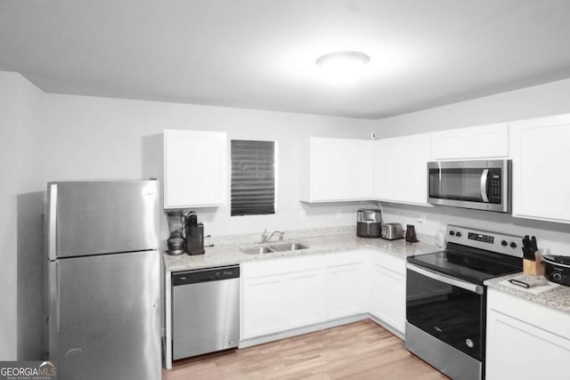 20 Sloane Ct Unit 64, Covington, GA 30016 - kitchen featuring stainless steel appliances, a sink, white cabinetry, and light wood finished floors