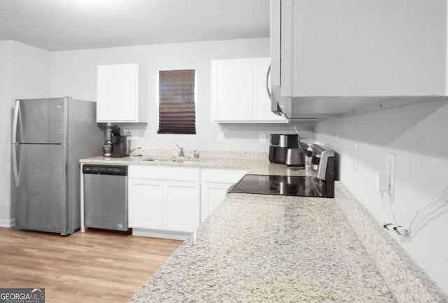 20 Sloane Ct Unit 64, Covington, GA 30016 - kitchen featuring stainless steel appliances, a sink, white cabinetry, and light wood-style floors